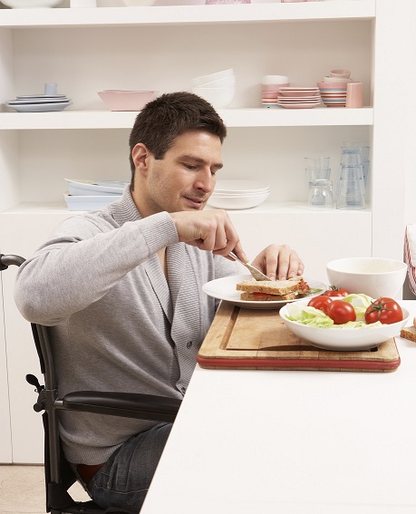 Image of a man in a wheelchair in his home.